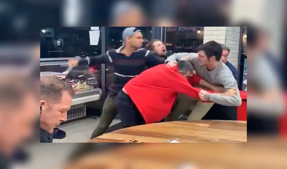 Un hombre imperturbable mira brutal pelea mientras come tranquilo sus papas fritas [VIDEO]