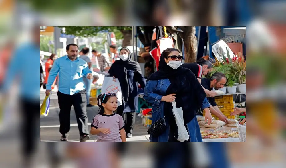Iranians, some wearing face masks, walk at a market in the capital Tehran on June 3, 2020, amid the novel coronavirus pandemic crisis. - The spread of novel coronavirus has accelerated again this month in Iran which today officially confirmed over 3,000 new cases for a third consecutive day. (Photo by - / AFP)