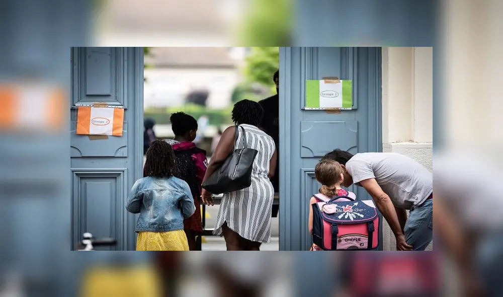 Parents and children arrive at the Jules Julien elementary school in Toulouse, southern France, on June 22, 2020 following the reopening of schools as France eases lockdown measures taken to curb the spread of the COVID-19 (the novel coronavirus). (Photo by Lionel BONAVENTURE / AFP)