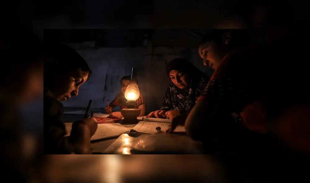 Los niños palestinos hacen sus deberes con una lámpara de gas durante un corte de energía después del cierre de la única planta de energía de Gaza en medio de la tensión con Israel. Foto: MAHMUD HAMS / AFP. Los niños palestinos hacen sus deberes con una lámpara de gas durante un corte de energía después del cierre de la única planta de energía de Gaza en medio de la tensión con Israel. Foto: MAHMUD HAMS / AFP.