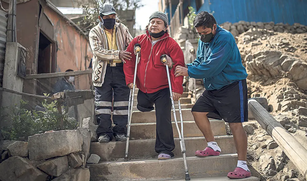 Bajar el cerro auxiliado por familiares y amigos es rutina de todos los días debido a que no hay barandas donde apoyarse. (Foto: Aldair Mejía)