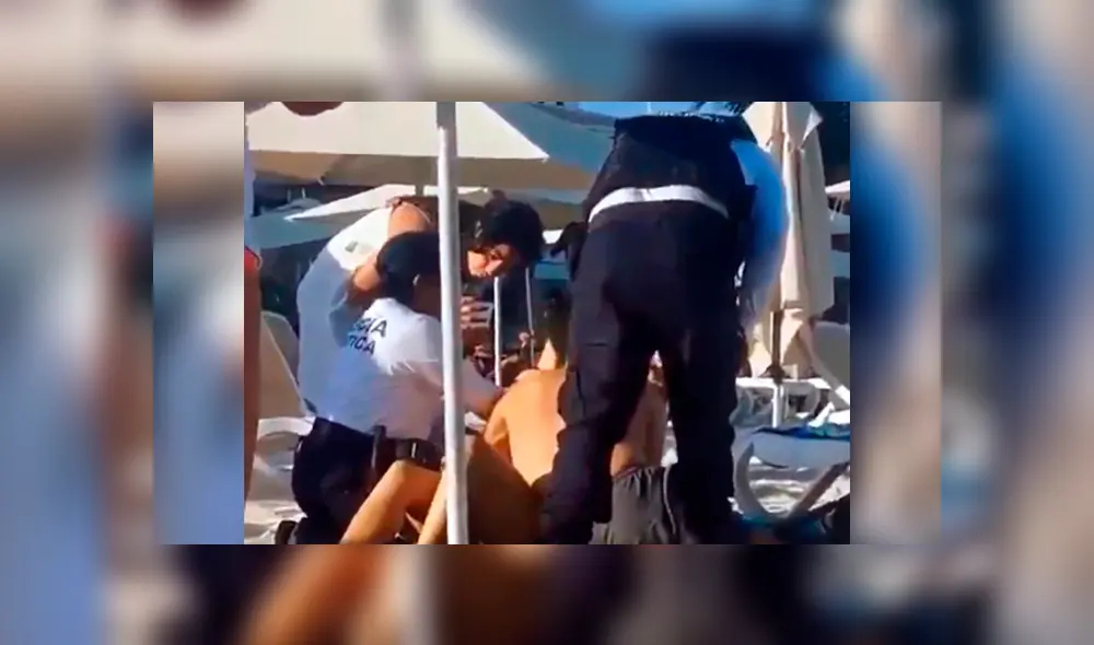 La pareja fue detenida bruscamente por las autoridades de la playa. (Foto: Captura)