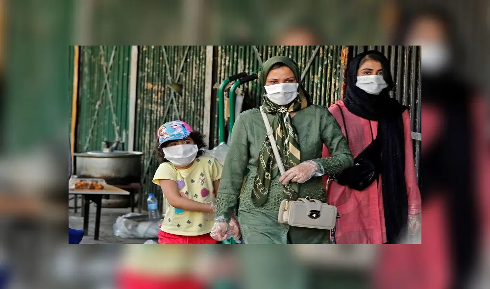 Iranians wearing face masks walk along a street in the capital Tehran on June 3, 2020, amid the novel coronavirus pandemic crisis. - The spread of novel coronavirus has accelerated again this month in Iran which today officially confirmed over 3,000 new cases for a third consecutive day. (Photo by - / AFP)