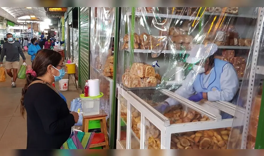 Una panadera protege su puesto con plástico para reducir el contacto con el cliente. Una panadera protege su puesto con plástico para reducir el contacto con el cliente.