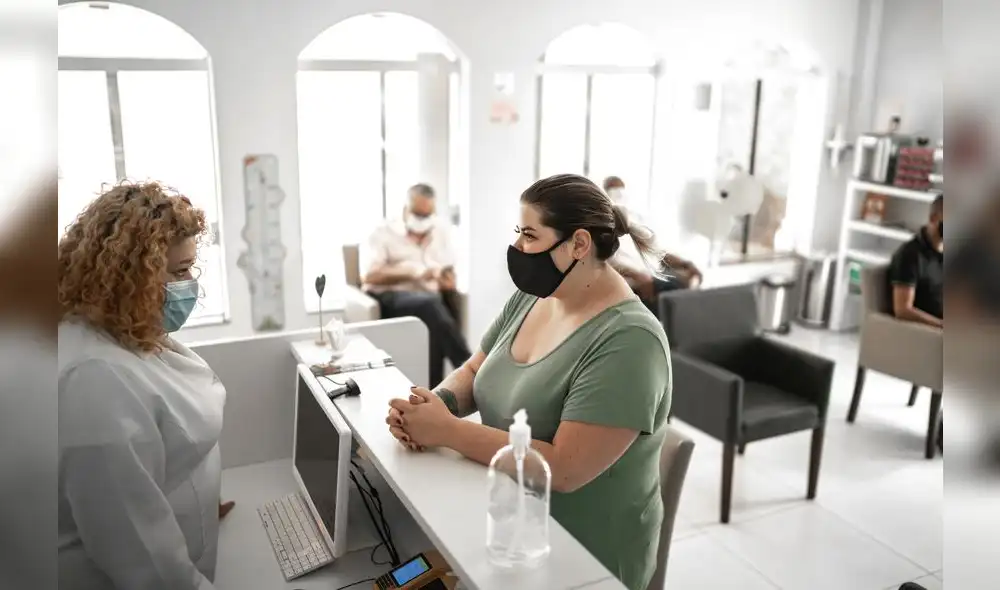 Medical clinic reception, patient waiting in line respecting social distancing