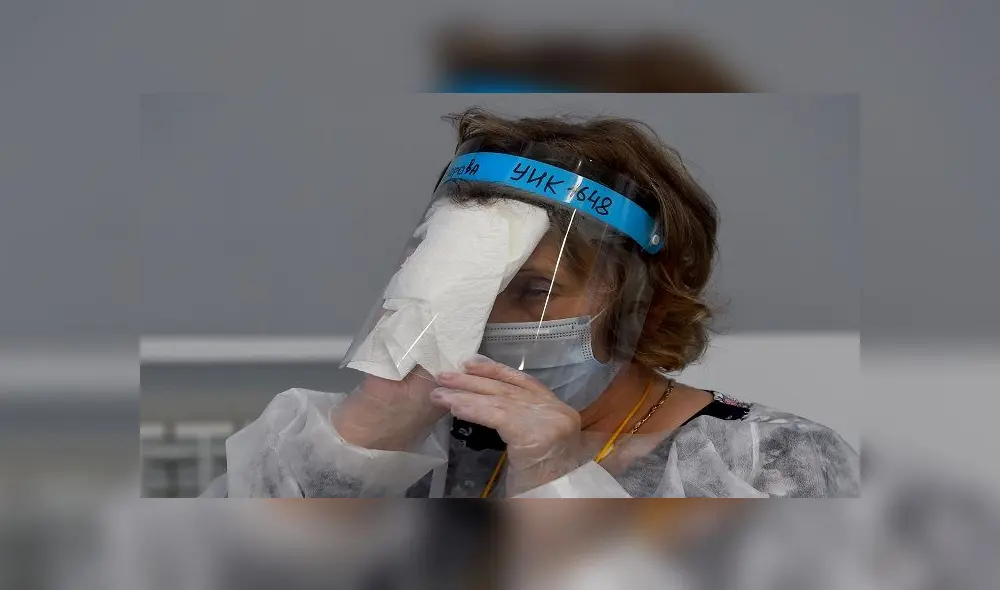 A member of a local electoral commission wearing protective gear - a measure against the spread of the coronavirus disease - wipes her face shield at a polling station during a nationwide vote on constitutional reforms in Saint Petersburg on July 1, 2020. (Photo by OLGA MALTSEVA / AFP) A member of a local electoral commission wearing protective gear - a measure against the spread of the coronavirus disease - wipes her face shield at a polling station during a nationwide vote on constitutional reforms in Saint Petersburg on July 1, 2020. (Photo by OLGA MALTSEVA / AFP)