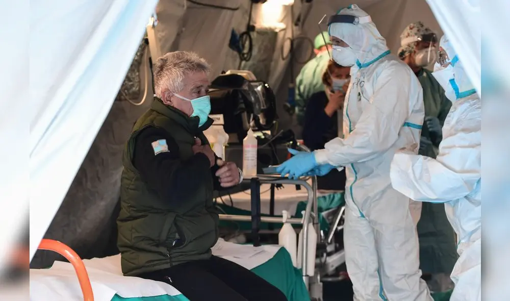 A patient sits in a tent to be tested for new coronavirus, at a temporary emergency structure set up outside the accident and emergency department, where any new arrivals presenting suspect symptoms are being tested, at the Brescia hospital, Lombardy, on March 13, 2020. (Photo by Miguel MEDINA / AFP) A patient sits in a tent to be tested for new coronavirus, at a temporary emergency structure set up outside the accident and emergency department, where any new arrivals presenting suspect symptoms are being tested, at the Brescia hospital, Lombardy, on March 13, 2020. (Photo by Miguel MEDINA / AFP)