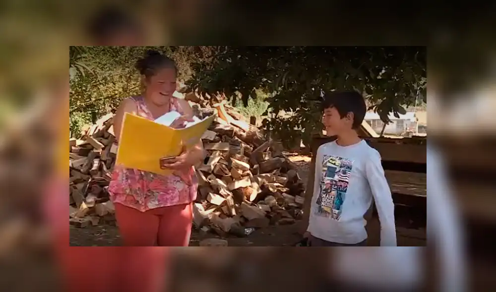 Una madre y su hijo reciben la guía de estudio durante la cuarentena. (Foto: Captura) Una madre y su hijo reciben la guía de estudio durante la cuarentena. (Foto: Captura)