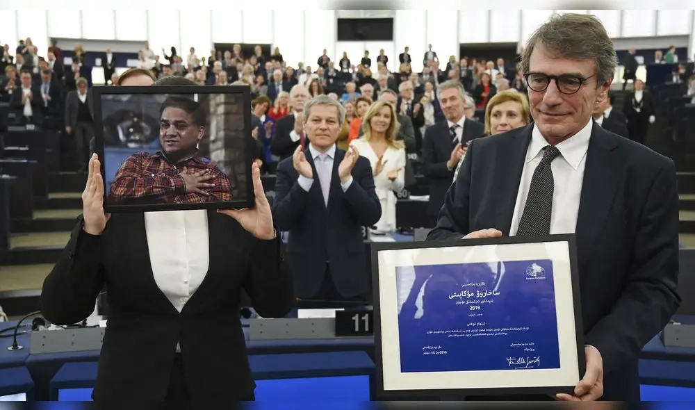 Jewher Ilham, hija de Ilham Tohti, economista uigur y activista de derechos humanos, sosteniendo un retrato de su padre. Jewher Ilham, hija de Ilham Tohti, economista uigur y activista de derechos humanos, sosteniendo un retrato de su padre.