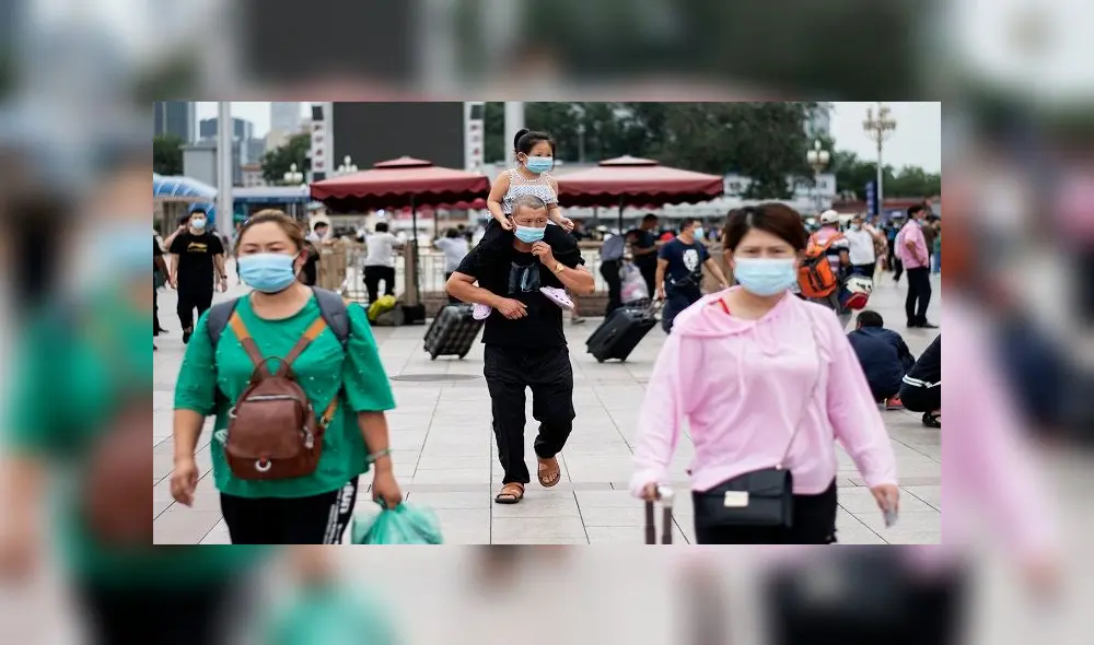 People wearing face masks arrive at Beijing Railway Station in Beijing on August 19, 2020. (Photo by NOEL CELIS / AFP)