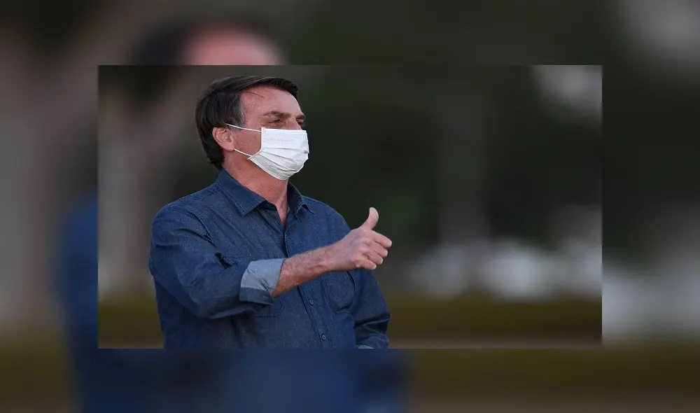 Brazilian President Jair Bolsonaro gives the thumb up while attending the flag unveiling ceremony at the Alvorada Palace in Brasilia, on July 15, 2020. - Brazil President Jair Bolsonaro tested positive for coronavirus again, CNN Brazil said on Wednesday, quoting the far right leader, who underwent a new test on Tuesday. (Photo by EVARISTO SA / AFP)