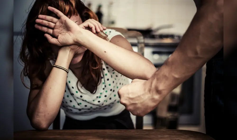 Woman is Covering Her Face In Fear Of Domestic Violence as her partner threatens her with his fist Woman is Covering Her Face In Fear Of Domestic Violence as her partner threatens her with his fist