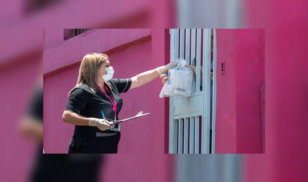 An employee of the Costa Rican Social Security Fund (CCSS) wears a face mask as she delivers medicines at people's homes during the outbreak of the new coronavirus in San Jose, on March 31, 2020. (Photo by Ezequiel BECERRA / AFP)