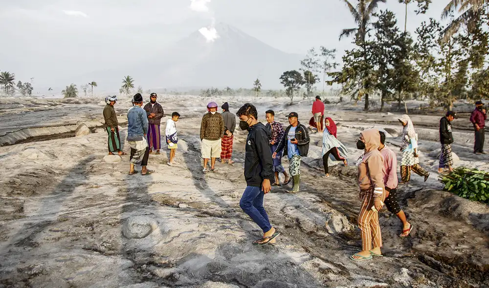 Cenizas y lodo. Vecinos caminan sobre toneladas de cenizas que cubren las calles de su pueblo. Foto: EFE Cenizas y lodo. Vecinos caminan sobre toneladas de cenizas que cubren las calles de su pueblo. Foto: EFE
