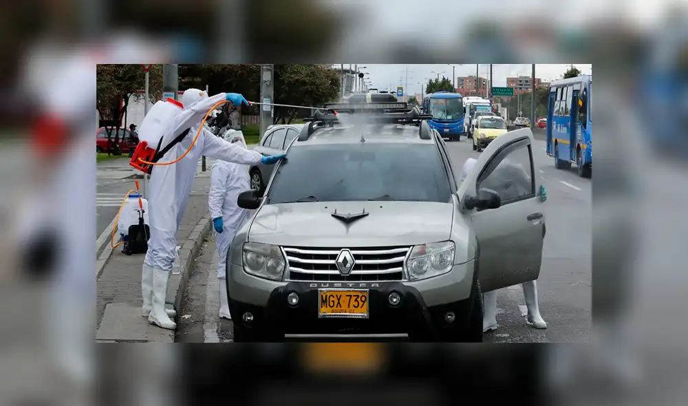 Vestidos con traje antifluido y equipados con contenedores de fumigación desinfectan todo tipo de vehículos. Vestidos con traje antifluido y equipados con contenedores de fumigación desinfectan todo tipo de vehículos.