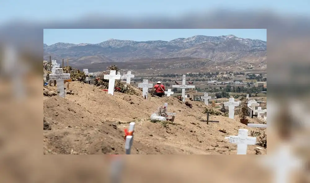 A musician walks between graves at the Municipal Cemetery #13 in Tijuana, Baja California state, Mexico on June 9, 2020, amid the COVID-19 pandemic. (Photo by Guillermo Arias / AFP) A musician walks between graves at the Municipal Cemetery #13 in Tijuana, Baja California state, Mexico on June 9, 2020, amid the COVID-19 pandemic. (Photo by Guillermo Arias / AFP)