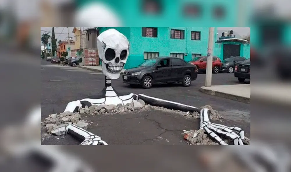 Vecinos utilizan baches en pistas para poner calaveras gigantes [VIDEO]