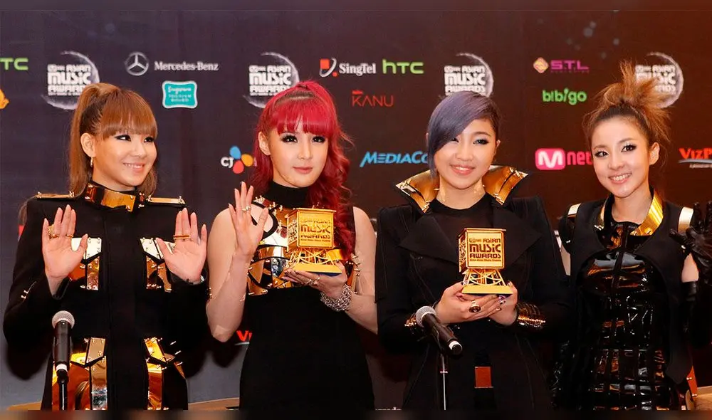 2NE1 en los MAMAs del 2011. Bom, de cabello rojizo, sostiene uno de sus premios. 2NE1 en los MAMAs del 2011. Bom, de cabello rojizo, sostiene uno de sus premios.