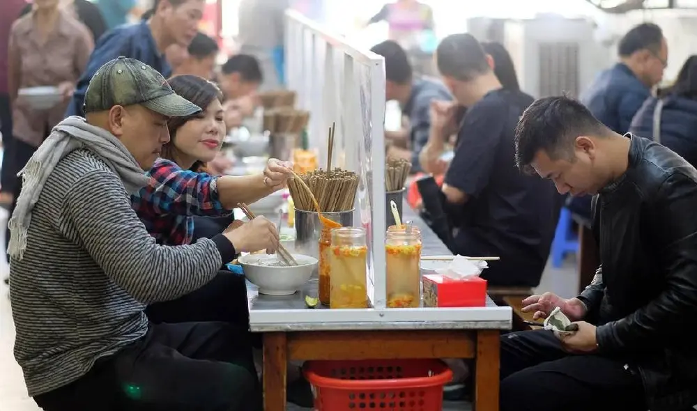 En Hanoi, ciudad más importante de Vietnam, las personas comen respetando la distancia social. Foto: EFE
