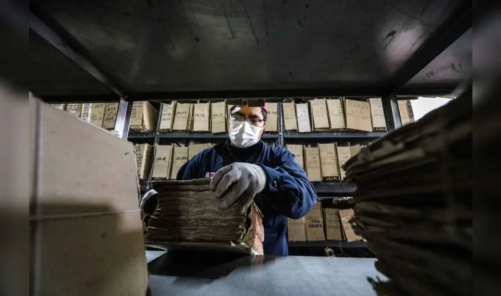 Trabajadores del Archivo Regional de Cusco manejan cuidadosamente los documentos.