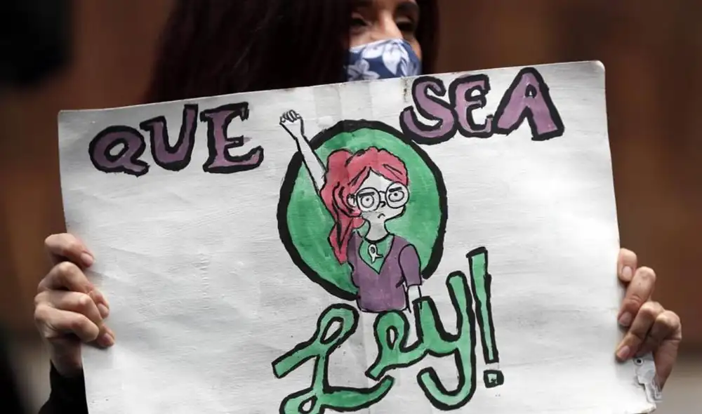 Durante la manifestación, las activistas feministas taparon un grafiti realizado por grupos antiabortistas. Foto: EFE