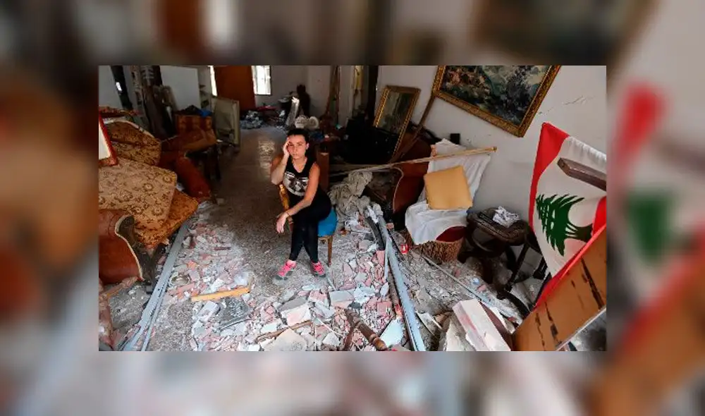Una mujer sentada entre los escombros de su casa en la capital libanesa, Beirut, el 6 de agosto de 2020. Foto: AFP.