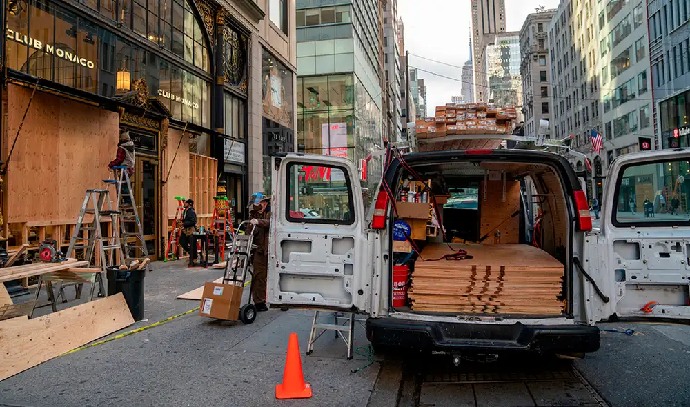 Empleados cubren los establecimientos comerciales con madera ante posibles disturbios durante los comicios presidenciales. Foto: AFP