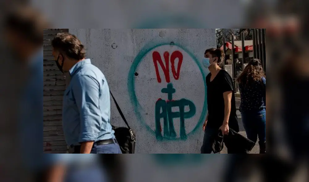 Personas pasan por un graffiti contra la Administración del Fondo de Pensiones (AFP) en Santiago. Foto: AFP. Personas pasan por un graffiti contra la Administración del Fondo de Pensiones (AFP) en Santiago. Foto: AFP.