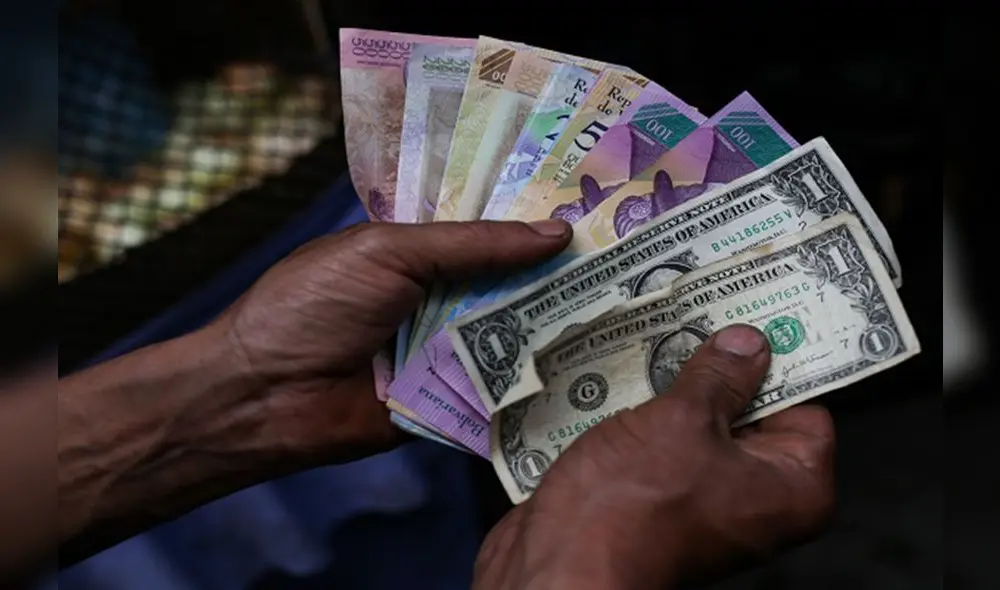 A market trader shows different currency notes in Caracas on March 10, 2019, during the third day of a massive power outage which has left Venezuelans without communications, electricity and water. - The unprecedented power outage already left 15 patients dead and threatens to extend indefinitely, increasing distress for the severe political and economic crisis hitting the oil-rich South American nation. (Photo by Cristian Hernandez / AFP) A market trader shows different currency notes in Caracas on March 10, 2019, during the third day of a massive power outage which has left Venezuelans without communications, electricity and water. - The unprecedented power outage already left 15 patients dead and threatens to extend indefinitely, increasing distress for the severe political and economic crisis hitting the oil-rich South American nation. (Photo by Cristian Hernandez / AFP)