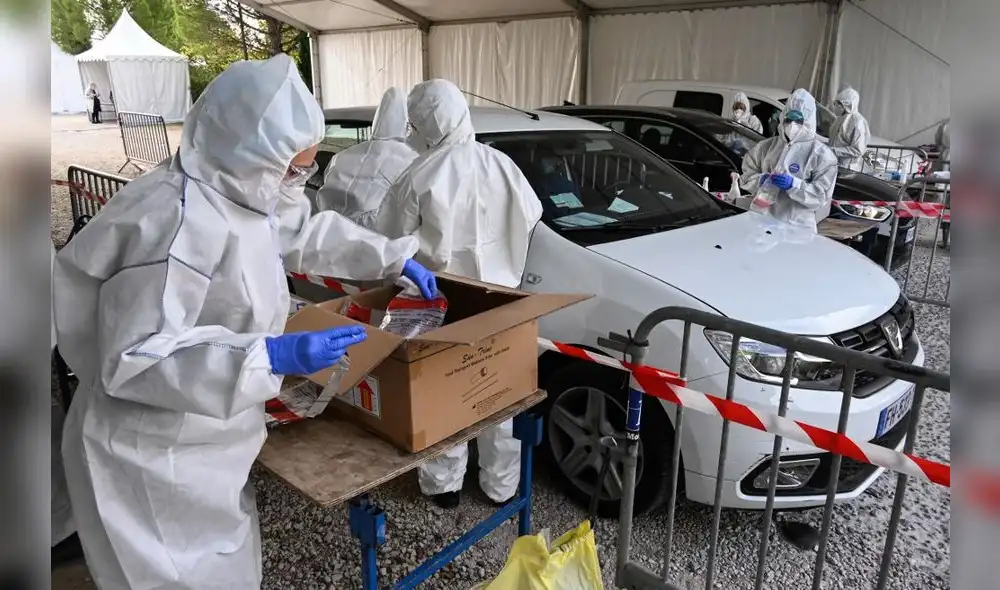 Firefighters and members of the French Red-Cross wearing protective suits perform tests and handle samples at a drive-through Covid-19 screening site on October 14, 2020 in Montpellier. - Faced with the resurgence of the epidemic in France, President Emmanuel Macron is expected to announce on October 14 evening new restrictive measures, even possible curfews, which should especially affect major cities where Covid-19 is running amok. (Photo by Pascal GUYOT / AFP) Firefighters and members of the French Red-Cross wearing protective suits perform tests and handle samples at a drive-through Covid-19 screening site on October 14, 2020 in Montpellier. - Faced with the resurgence of the epidemic in France, President Emmanuel Macron is expected to announce on October 14 evening new restrictive measures, even possible curfews, which should especially affect major cities where Covid-19 is running amok. (Photo by Pascal GUYOT / AFP)