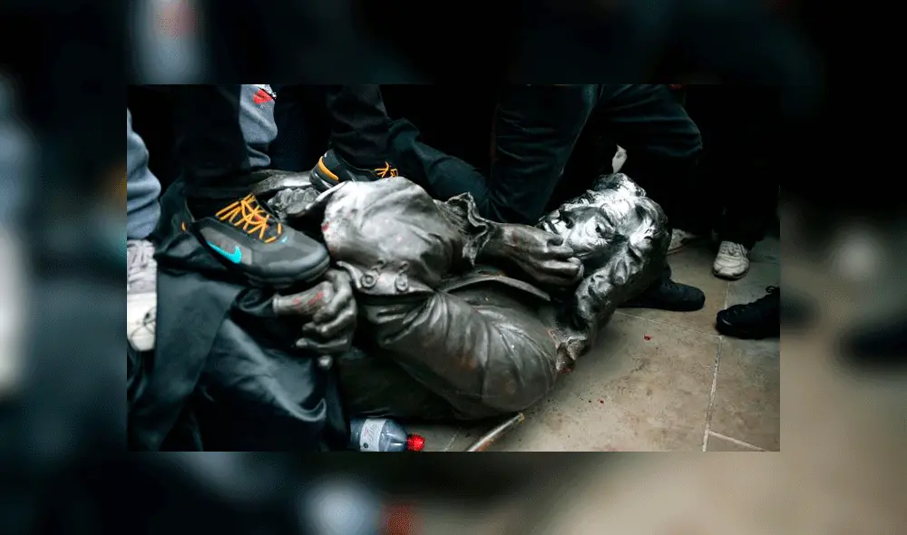 Un protestante puso su rodilla sobre el cuello de la estatua. Fuente: AP. Un protestante puso su rodilla sobre el cuello de la estatua. Fuente: AP.