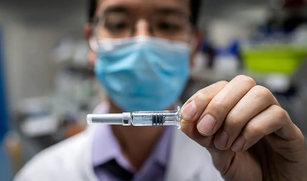 Ingeniero muestra una vacuna experimental para el coronavirus (COVID-19), en Beijing, China. | Foto: Nicolas Asfouri / AFP