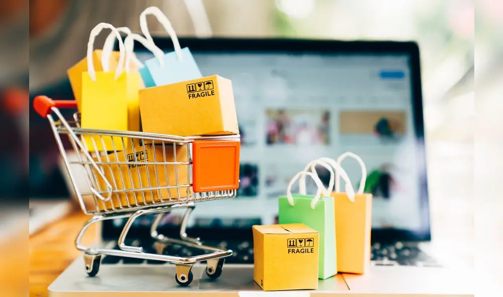 Product package boxes and shopping bag in cart with laptop computer which web store shop on screen for online shopping and delivery concept