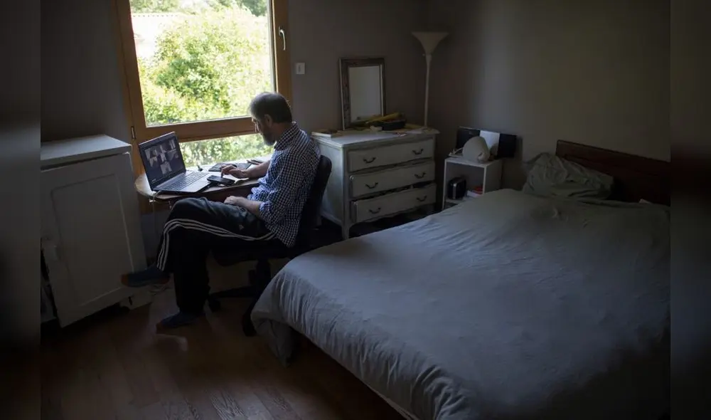 (FILES) In this file photo taken on May 14, 2020 a man takes part in a video conference as he works from home, in Vertou, outside Nantes, as France eases lockdown measures taken to curb the spread of the COVID-19 pandemic, caused by the novel coronavirus. - Specialists warn that working from home, which has become a  
solution for millions during the coronavirus pandemic, can bear risks if it is not done in a moderate way. (Photo by Loic VENANCE / AFP)