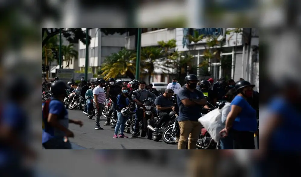 Bikers wait in a queue to refuel their tanks at a gas station, in Caracas on June 1, 2020 amid the novel COVID-19 coronavirus outbreak. - Venezuela will increase fuel prices in June, President Nicolas Maduro said on Saturday, putting a limit on state subsidies that for decades had allowed citizens to fill their gas tanks virtually for free. (Photo by Federico PARRA / AFP)