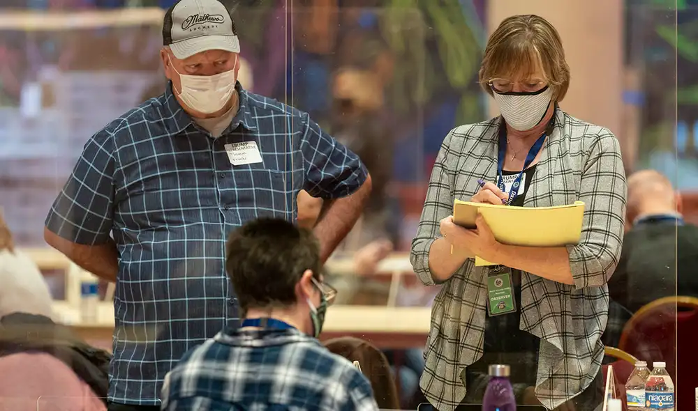 Un trabajador electoral muestra las boletas a los representantes del presidente Donald Trump. Foto: AFP