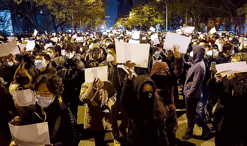 Gesto. En Shanghái marchan con papeles blancos por víctimas de un incendio en un edificio de confinados, en Urumqi. Foto: difusión Gesto. En Shanghái marchan con papeles blancos por víctimas de un incendio en un edificio de confinados, en Urumqi. Foto: difusión
