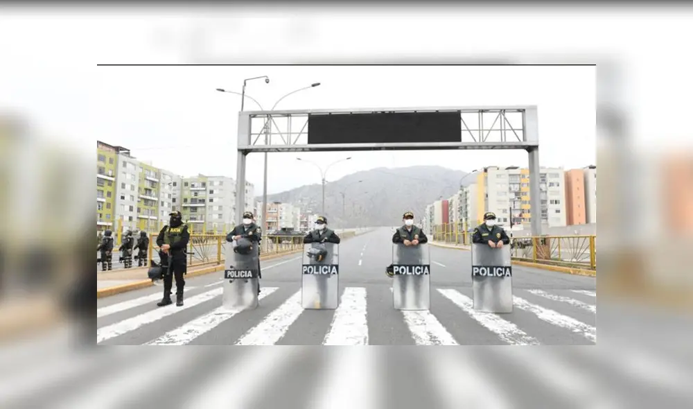 Policías resguardan calle para hacer cumplir restricciones. (Foto: Andina)