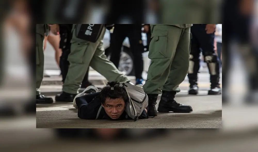 Riot police detain a man as they clear protesters taking part in a rally against a new national security law in Hong Kong on July 1, 2020, on the 23rd anniversary of the city's handover from Britain to China. - Hong Kong police made the first arrests under Beijing's new national security law on July 1 as the city greeted the anniversary of its handover to China with protesters fleeing water cannon. (Photo by DALE DE LA REY / AFP)