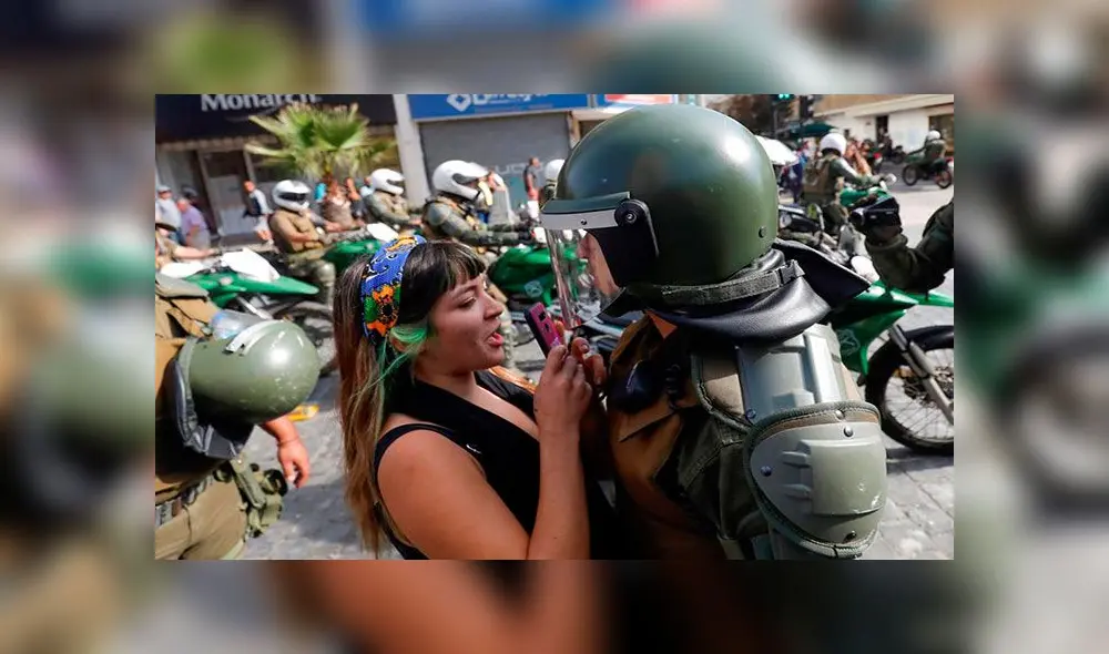 Una manifestante se enfrentó a un policía y lo grabó con su teléfono. Foto: EFE Una manifestante se enfrentó a un policía y lo grabó con su teléfono. Foto: EFE