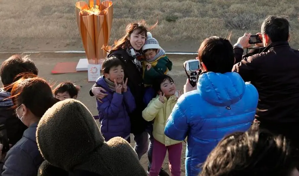 Pese a las advertencias de las autoridades sanitarias, un público numeroso se congregó en torno al fuego representativo de los Juegos Olímpicos. Foto: EFE.