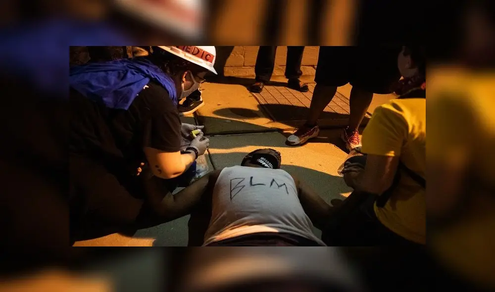 KENOSHA, WI - AUGUST 25: A demonstrator passes out during a clash with law enforcement on August 25, 2020 in Kenosha, Wisconsin. As the city declared a state of emergency curfew, a third night of civil unrest occurred after the shooting of Jacob Blake, 29, on August 23. Video shot of the incident appears to show Blake shot multiple times in the back by Wisconsin police officers while attempting to enter the drivers side of a vehicle. The 29-year-old Blake was undergoing surgery for a severed spinal cord, shattered vertebrae and severe damage to organs, according to the family attorneys in published accounts.   Brandon Bell/Getty Images/AFP