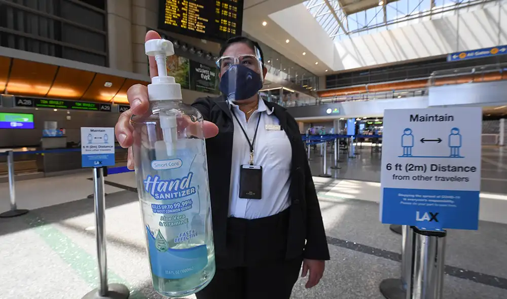 La empleada del aeropuerto internacional de Los Ángeles, Gigi Bebikian, con una botella de desinfectante de manos. | Foto: Robyn Beck / AFP La empleada del aeropuerto internacional de Los Ángeles, Gigi Bebikian, con una botella de desinfectante de manos. | Foto: Robyn Beck / AFP