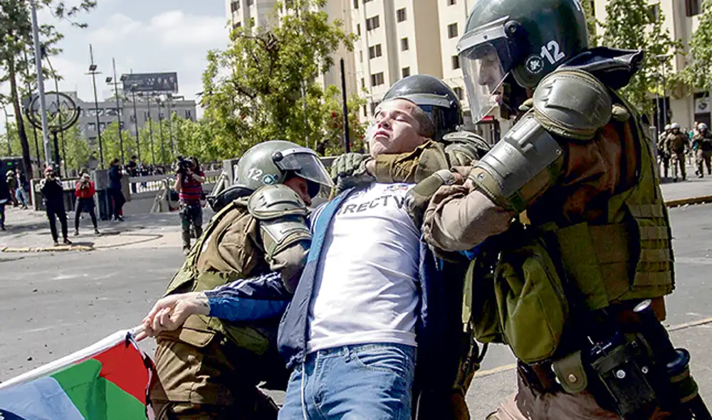 Contención. Carabineros y el Ejército apresan a los jóvenes.