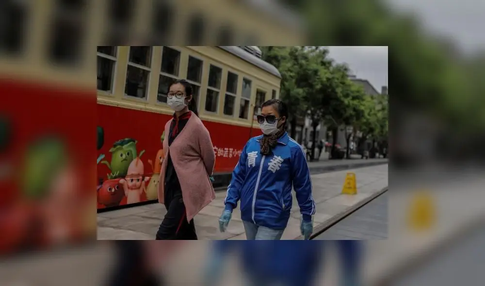 Mujeres caminan por la calle con guantes y mascarillas. Foto: EFE. Mujeres caminan por la calle con guantes y mascarillas. Foto: EFE.