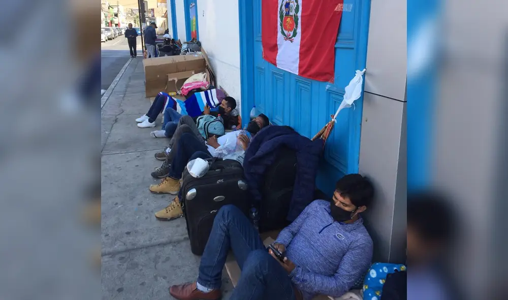Peruanos esperan afuera de consulado.