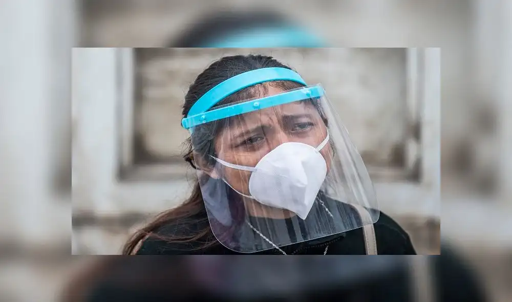 A woman mourns during the funeral of her relative, victim of Covid-19, at El Angel cemetery in Lima on May 21, 2020. - Peru has become the second Latin American country after Brazil to reach 100,000 coronavirus cases, according to health ministry figures out Wednesday. (Photo by ERNESTO BENAVIDES / AFP)