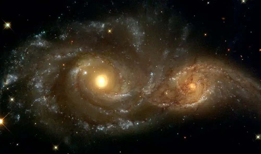 Representación artística de una gran galaxia engullendo a otra en su juventud | Foto referencial: NASA