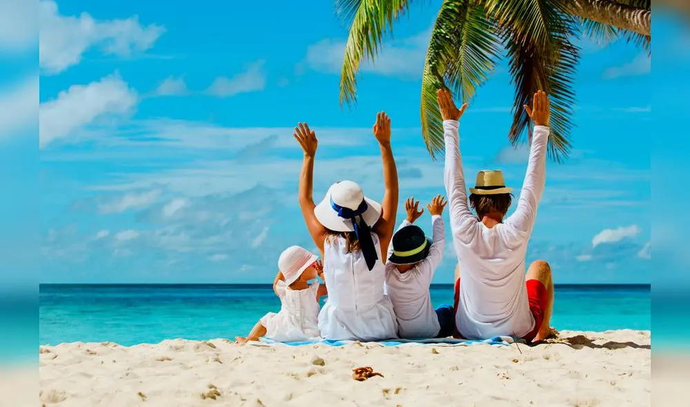 happy family with two kids hands up on tropical beach
