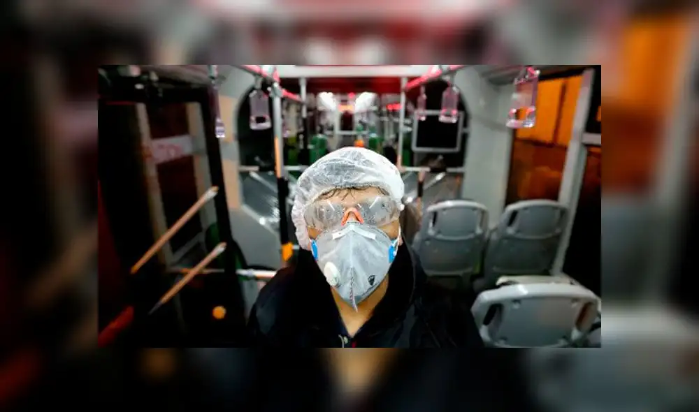 Un trabajador del municipio de Teherán limpia un autobús para evitar la propagación de la enfermedad COVID-19. Foto: AFP.